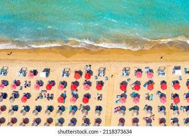 Zakynthos Island, Greece. Top view aerial drone photo of Banana beach with beautiful turquoise water, sea waves and red umbrellas. Vacation travel background. Ionian sea.