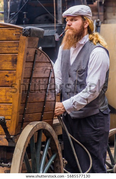 ZAMBERK,\
CZECHIA - SEPTEMBER 15, 2018: Man in period clothes tends a steam\
car in the Old Machines and Technologies Museum (Muzeum starych\
stroju a technologii) in Zamberk,\
Czechia.