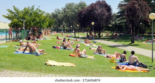 Zamora / Spain - August 23, 2009: 
People Sunbathing On The Grass Of A Public Swimming Pool During The Summer