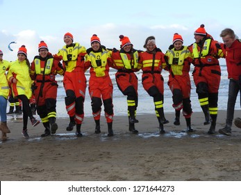 Zandvoort, The Netherlands - 1 Januari 2019: Traditional New Years Dive
North Sea. Dancing Water Rescue Team With Ice Cap.
