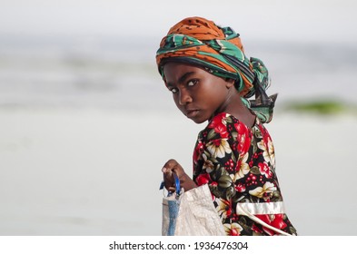 Zanzibar Island, Tanzania - July 07, 2014: Portrait of a young woman of the island Zanzibar. She stands half-turned in a bright colored dress
