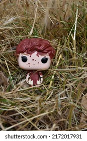 Zaporizhzhia, Ukraine - June 22, 2022: Funko Pop Collection Figure Of Beverly Marsh From Horror Slasher Movie It. Halloween Vinyl Bloody Toy Standing Among Thickets Of Dry Reeds, Straw And Spikelets.