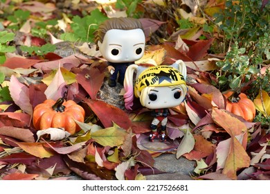 Zaporizhzhia, Ukraine - October 19, 2022: Funko Pop Action Figures. Serial Killer Michael Myers From Horror Movie Halloween Attacking With Knife Harley Quinn In Fall Garden. Autumn Leaves, Pumpkins.