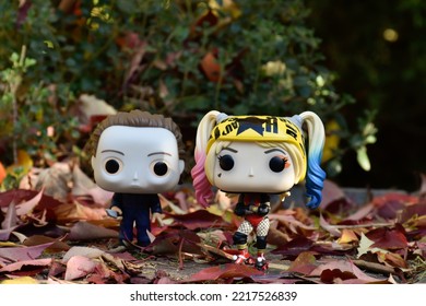 Zaporizhzhia, Ukraine - October 19, 2022: Funko Pop Action Figures Of Serial Killer Michael Myers From Horror Movie Halloween And Harley Quinn Walking Down Street, Park, Fall Leaves, Spooky Season.