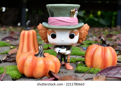 Zaporizhzhia, Ukraine - October 4, 2022: Funko Pop Action Figure Of Mad Hatter From Movie Alice In Wonderland. Green Moss In Fabulous Autumn Garden, Fallen Leaves, Halloween Pumpkins Decorations.