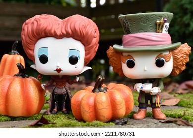 Zaporizhzhia, Ukraine - October 4, 2022: Funko Pop Vinyl Action Figures Of Mad Hatter And Red Queen From Movie Alice In Wonderland. Green Moss In Magical Autumn Garden, Halloween Pumpkin Decorations.