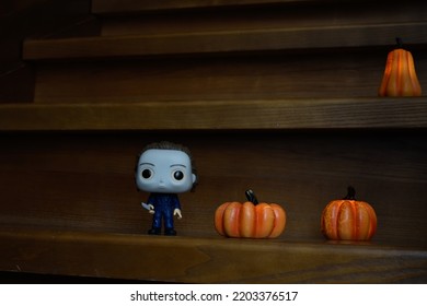 Zaporizhzhia, Ukraine - September 16, 2022: Funko Pop Vinyl Action Figure Of Serial Killer Michael Myers From Popular Horror Movie Halloween. Wooden Stairs In Dark House, Pumpkins, Spooky Atmosphere.