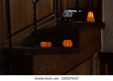 Zaporizhzhia, Ukraine - September 16, 2022: Funko Pop Vinyl Action Figure Of Serial Killer Michael Myers From Popular Horror Movie Halloween. Wooden Stairs In Dark House, Pumpkins, Spooky Atmosphere.