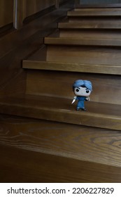 Zaporizhzhia, Ukraine - September 22, 2022: Funko Pop Vinyl Action Figure Of Serial Killer Norman Bates From Popular Horror Movie Psycho Standing On Wooden Stairs In Dark House, Spooky Atmosphere.