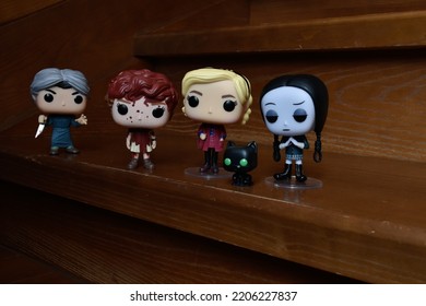 Zaporizhzhia, Ukraine - September 22, 2022: Funko Pop Vinyl Collection Action Figures Of Beverly Marsh, Sabrina Spellman, Wednesday Addams And Norman Bates Attacking Them With Knife On Wooden Stairs.