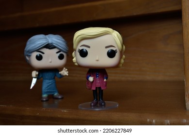 Zaporizhzhia, Ukraine - September 22, 2022: Funko Pop Action Figures Of Sabrina Spellman And Norman Bates From Movie Psycho. Killer Attacking Teenage Witch With Knife On Dark Wooden Stairs. 