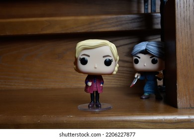 Zaporizhzhia, Ukraine - September 22, 2022: Funko Pop Action Figures Of Sabrina Spellman And Norman Bates From Movie Psycho. Killer Attacking Teenage Witch With Knife On Dark Wooden Stairs. 