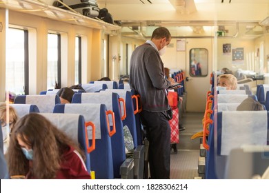 Zaragoza, Spain - September 29, 2020: One of the Renfe reviewers, asks passengers for tickets on the regional express train to Pamplona, originating at the Delicias train station, Zaragoza.