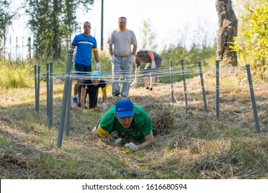 Zarinsk, Russia-August 18, 2018: Team Game In The Summer On The Street, Team Building Games, Sports Games, Running With An Obstacle, Skating, Climbing A Rope, Running In The Sand