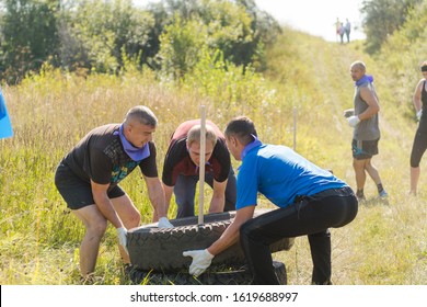 Zarinsk, Russia-August 18, 2018: Team Game In The Summer On The Street, Team Building Games, Sports Games, Running With An Obstacle, Skating, Climbing A Rope, Running In The Sand