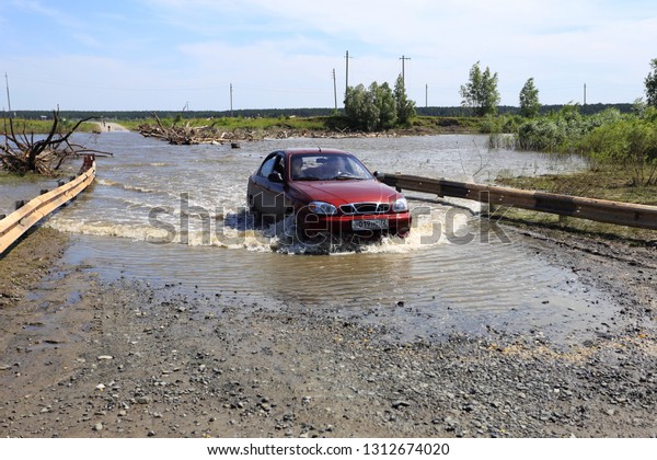 Zavodoukovsk
city, Tyumen region, Russia, June 14, 2014: Tobol river Crossing
over the flooded bridge. Floating
cars.
