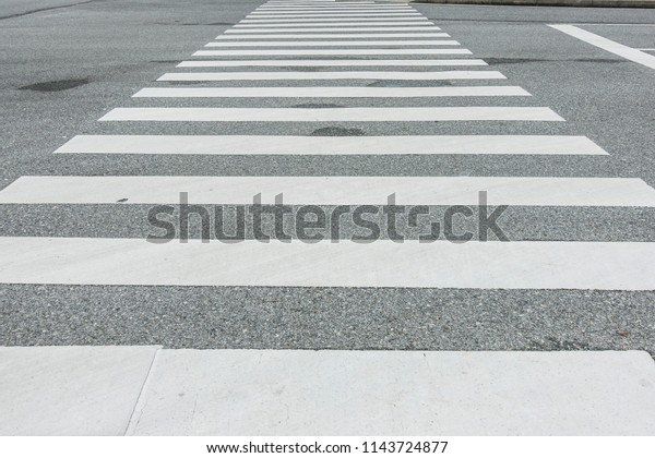 Zebra crosswalk on the road, safety\
when people walking cross the street, Pedestrian crossing, asphalt\
road, White lines and crosswalk on street background \
