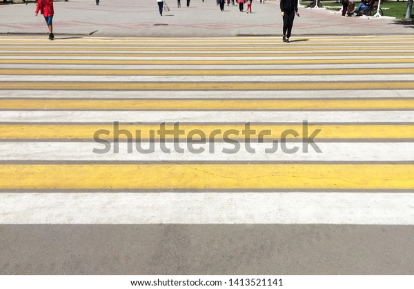 Zebra traffic pedestrian walkway in the city.\
Yellow and white stripes.