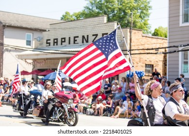 Zelienople, PA USA July 4 2022: Motorcyclists Ride Through Main Street Zelienople Carrying An American Flag On A Sunny Fourth Of July Parade Day.