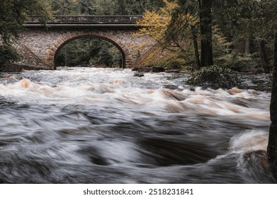 Zemska Brana, old stone bridge over the river Divoka orlice in the valley of the Orlicke mountains. Early Autumn scenery with  trees, stones and wild river after heavy rain. - Powered by Shutterstock