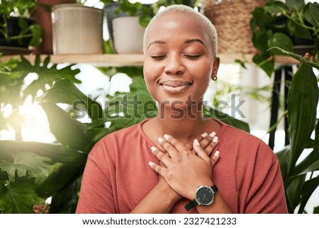 Zen, breathing and calm woman by plants for breathing exercise in meditation in a nursery. Breathe, gratitude and young African female person with a relaxing mindset by an indoor greenhouse garden.