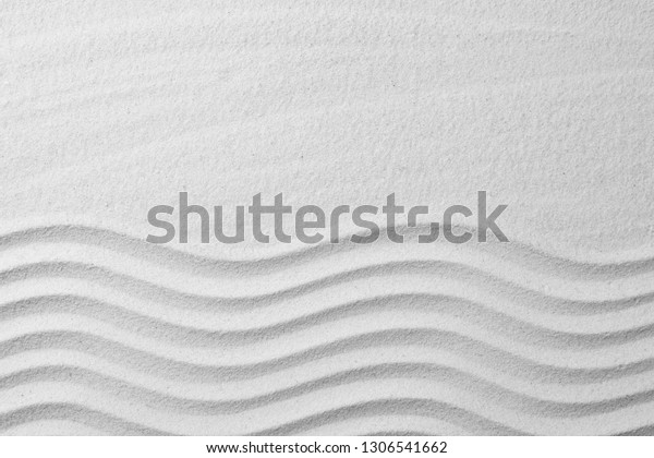 Zen garden pattern on sand as\
background, top view with space for text. Meditation and\
harmony