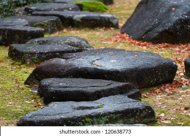 Zen Stone Path In A Japanese Garden With Fallen Leaves Of Maple In-between