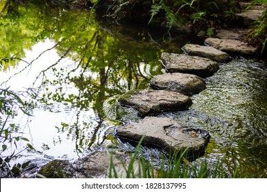 Zen Stone Path Over A Pond In A Japanese Garden