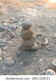 Zen Stone Stack Balancing on Natural Ground During Serene Golden Hour Sunset Light for Mindfulness and Meditation Practice