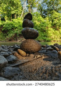 Zen stone stack on a pebble beach near a river, concept of balance, stability, and meditation in nature