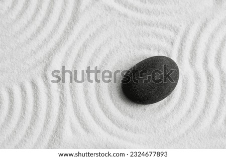 Zen Stone with White Sand Texture Background, Top View Zen Garden with Black Rock Sea Stone on Sand  Wave Parallel Lines Pattern in Japanese stye, Banner for Harmony,Meditation,Zen like concept