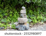 Zen stones, balance tower, green shamrock leaves background,  japanese garden