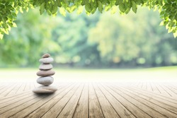 Zen камни на пустой деревянный с зеленым листом на фоне сада размыто и. Концепция релаксации, дзен, весна.
