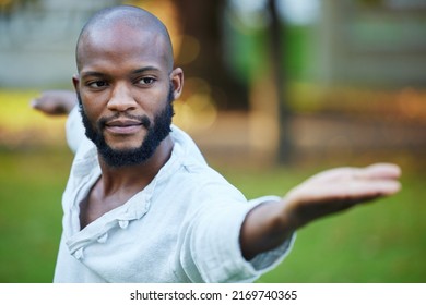 In The Zen Zone. Cropped Shot Of A Handsome Young Man Practicing Yoga Outside In The Park.