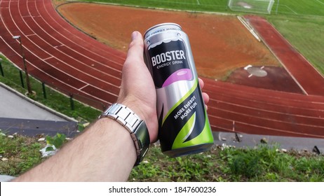 Zenica, Bosnia&Herzegovina, August 03, 2019 - Man's hand holding bottle of energy drink. Athletic stadium in background. Shallow depth of field.