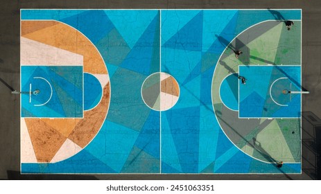 Zenith aerial view on boys playing basketball in city suburb court. The asphalt of the floor is colored. Basketball playground. - Powered by Shutterstock