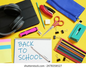 Zenith view, back to school, supplies, various accessories and  technology, in full color and yellow background. - Powered by Shutterstock