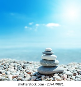 zen-like stones on beach and sun in sky. soft focus on bottom - Shutterstock ID 239479891