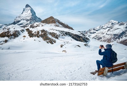 ZERMATT, SWITZERLAND - APR 11,2022: A tourist taking picture of  Matterhorn from Schwarzsee cable car station, Zermatt (Selective Focus)