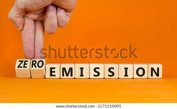 Zero\
emission symbol. Businessman turns wooden cubes and changes words\
Emission to Zero emission. Beautiful orange background. Business,\
ecological and zero emission concept. Copy\
space.