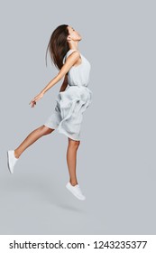 Zero Gravity. Full Length Of Beautiful Young Asian Woman Hovering Against Grey Background