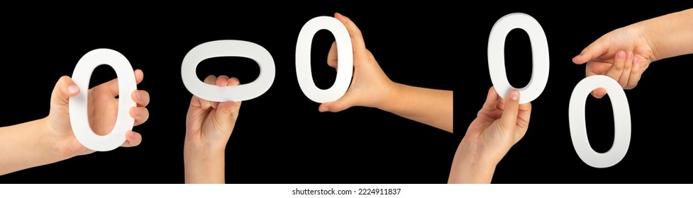 Zero in hand.Big set. The number zero is clasped in a hand isolated on a black background. Number zero white in a child's hand on a black background.