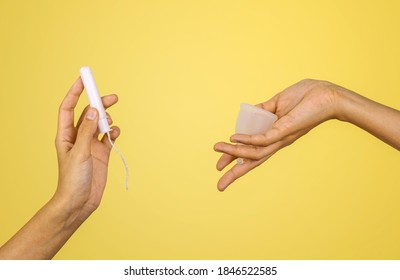 Zero Waste Alternative Consept. Tampon Vs Menstrual Cup. Woman Hands On Pastel Yellow Background. Hygiene Period Product.