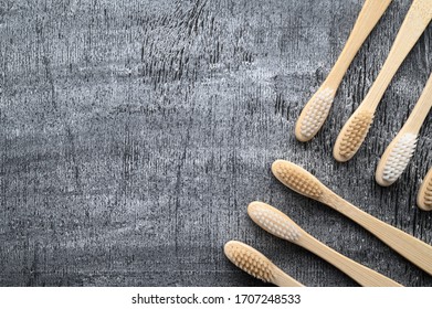 Zero Waste And Beyond Plastic Concept. Group Of Eco Natural Bamboo Toothbrushes On A Gray Wooden Background. From Above, Copy Space, Horizontal Orientation. Layout Natural Organic Hygiene Products.