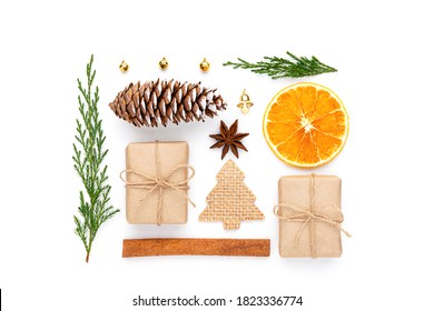 Zero waste christmas composition with craft gifts, fir tree, dry orange, cinnamon stick, bell, pine cone, star anise, golden baubles, thuja, and wooden tree on white background. - Powered by Shutterstock