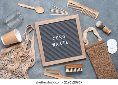 Zero Waste Concept. Bath Accessories And Kitchen Utensils Are Eco-friendly. Zero Waste Inscription On Letter Board. Gray Grunge Background. Top View, Flat Lay.