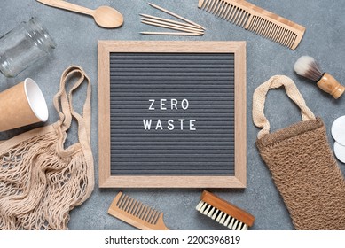 Zero Waste Concept. Bath Accessories And Kitchen Utensils Are Eco-friendly. Zero Waste Inscription On Letter Board. Gray Grunge Background. Top View, Flat Lay.