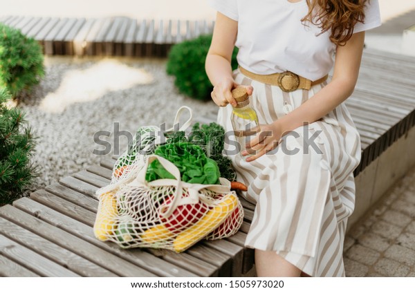 Zero waste\
concept with copy space. Woman holding cotton shopper and reusable\
mesh shopping bags with vegetables, products. Eco friendly mesh\
shopper. Zero waste, plastic free\
concept