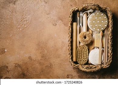 Zero waste concept. Eco friendly bathroom and kitchen accessories in a wicker basket on a beige background. Flat lay, top view, copy space.