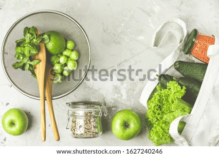 Zero waste concept. Eco-friendly shopping, flat lay. Fresh organic green vegetables and fruits on gray background. Spring diet, healthy raw vegetarian, vegan concept, alkaline clean eating